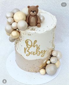 a baby shower cake with a teddy bear on top