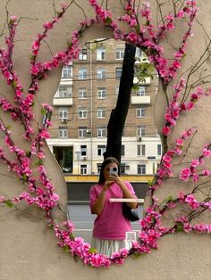 a woman taking a selfie in front of a mirror with pink flowers on it