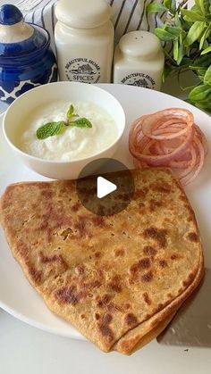 a white plate topped with quesadillas next to a bowl of yogurt