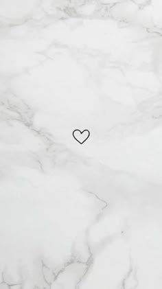 a white marble with a black heart on the middle and red border around it,