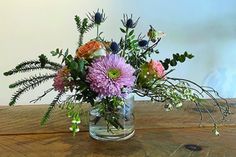 a vase filled with flowers on top of a wooden table