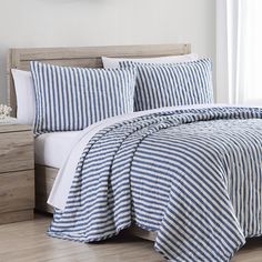 a blue and white striped comforter set on a bed