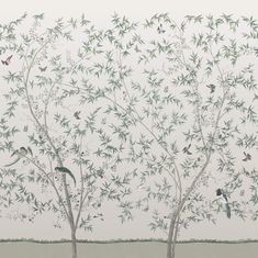 two trees with birds on them in front of a white wall