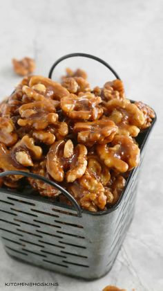 a metal basket filled with nuts on top of a table