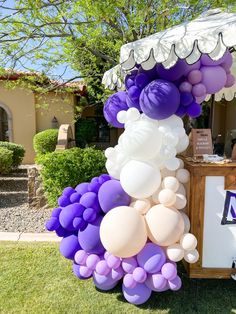 a bunch of balloons that are on the ground in front of a table with an umbrella