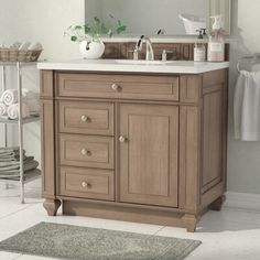 a bathroom with a sink, mirror and towels on the rack in front of it