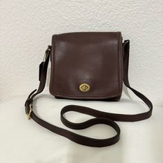 Vintage Coach Legacy Small Companion 9076 Leather Crossbody Front Flap In The Color Chocolate Brown Vintage 2000, Turnlock Legacy Leather Flap Crossbody Bag Authentic Vintage Leather Coach Companion Compact Pouch Flap Crossbody Bag, Style Number 9076. Bass Turn-Lock Closure. Backside Has Slip Pocket. Inside Zipper Pocket. Made In Mexico. Adjustable Strap, Brass Hardware. Original Hangtag. Made Of 100% Buttery Soft, Supple & Very Durable Glove Tanned Cowhide Leather. *It Has Vintage Wear Given Its Age, Some Discoloration At The Edges But Otherwise In Excellent Condition. Some Scratches On The Turnlock. Vintage Coach Motto; Glove Tanned Cowhide, The Scars, Scratches, Veins & Wrinkles A Classic Soft Leather Crossbody Flap Bag, Coach Leather Crossbody Bag, Classic Coach Leather Flap Bag, Coach Brown Crossbody Saddle Bag, Vintage Coach Bag, Coach Leather-lined Crossbody Bag, Vintage Coach Bags With Leather Handles, Vintage Coach Bags 1970s, Brown Coach Bags For On-the-go