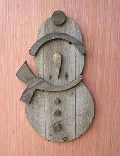 a snowman made out of wooden planks on a pink wall