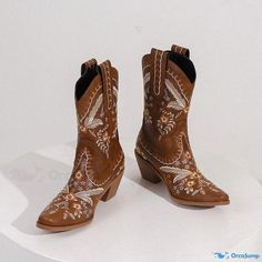 a pair of brown cowboy boots with embroidered designs