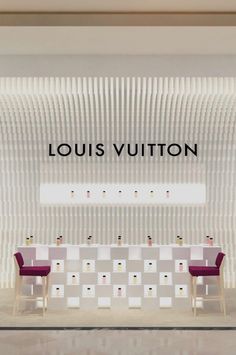 the louis vutton store front with two chairs and a table in front of it