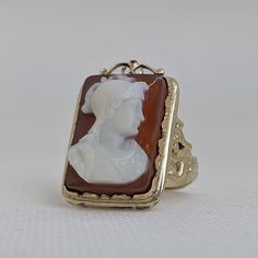 This gorgeous vintage cameo ring is beautifully crafted in a solid 14k gold frame with details at every angle. The victorian style is likely a 1930-1950s creation. In the center is a carved shell cameo of a Roman soldier. The cameo is in excellent condition and the sturdy ring measures approximately 26.45mm tall (including gold filigree fame) x 17.37mm wide. The ring is currently a ring size 7.5 but can be resized by your trusted local jeweler. A bold statement ring for men and women who love an Antique Cameo Ring Collectible, Vintage 14k Gold Cameo Rings, Vintage Carved Signet Ring For Formal Occasions, Art Deco Cameo Ring For Collectors, Art Deco Cameo Ring Collectible, Art Deco Cameo Collectible Rings, Victorian Gold Cameo Rings, Vintage Cameo Signet Ring, Vintage Carved Rings For Formal Events