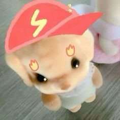 a small stuffed animal wearing a red hat with lightning bolt on it's head