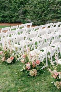 rows of white chairs with pink flowers on them