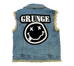 Experience the ultimate coolness with this medium denim wash vest featuring raw edge sleeves and button closure. Adorned with trendy patches and buttons, it's the must-have for all Grunge kids fans! Trendy Distressed Cotton Denim Vest, Trendy Distressed Denim Vest For Streetwear, Grunge Distressed Cotton Denim Vest, Grunge Kids, Trendy Patches, Grunge Denim, Kids Fans, Foxtrot, Denim Vest