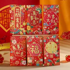 four red packets with chinese writing on them sitting on a table next to other items