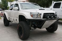 a white truck parked in front of two other trucks