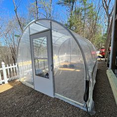 a small white house with a plastic covering on it's roof and side door