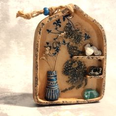 a blue and white vase sitting on top of a shelf filled with rocks, stones and plants