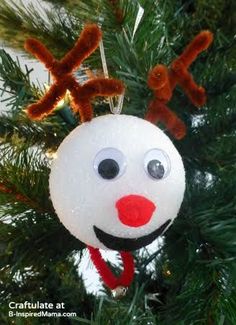 an ornament hanging from a christmas tree with reindeer nose and nose on it