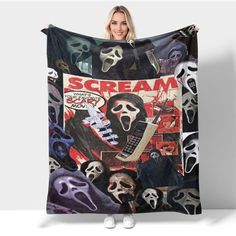 a woman holding up a blanket with scream on it