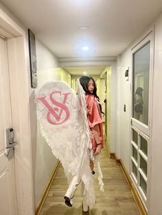 a woman is standing in the hallway with an angel costume