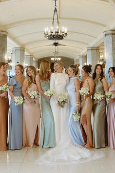 a group of women standing next to each other in front of a chandelier