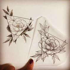 two pieces of paper with flowers drawn on them, one is white and the other has black ink