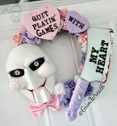 a wreath made to look like a mask with the words quit playin'games on it