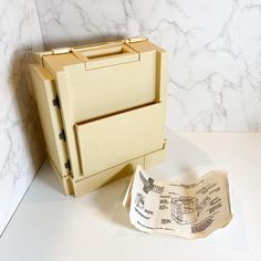 an open file cabinet sitting on top of a counter next to a piece of paper