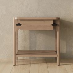 a wooden table with two black handles on the top and one drawer open, in front of a white wall