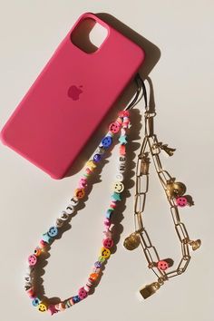 a red cell phone case sitting on top of a computer screen next to a necklace