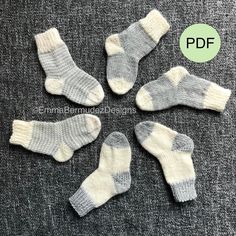 four pairs of socks sitting on top of a gray floor next to each other with white and grey stripes