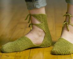 a woman's feet wearing green socks with laces on them