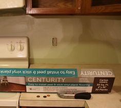 a white microwave oven sitting on top of a kitchen counter next to a box of glue