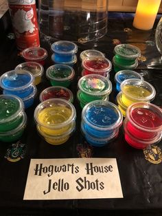 many different colored jello shots are on the table with a sign that says hogwart's house