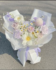 a bouquet of flowers is wrapped in white paper