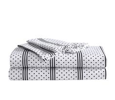 the white and black polka dot sheet set is folded up on top of each other