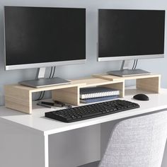 two computer monitors sitting on top of a white desk