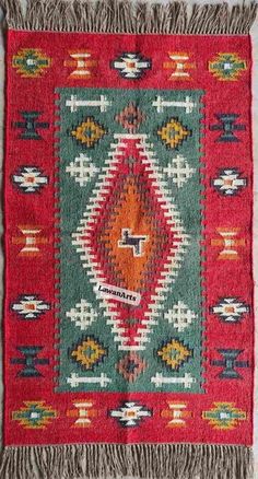 a red and green rug with fringes on it