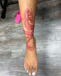 a woman's foot with a dragon tattoo on it