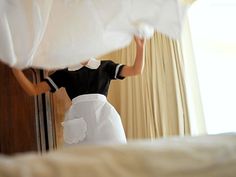 a woman in a black and white dress is holding curtains