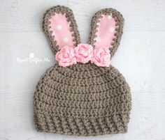 a crocheted bunny hat with pink flowers on it