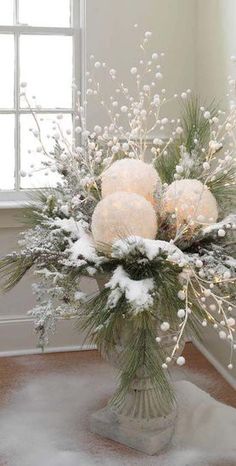 a vase filled with white flowers on top of a wooden floor next to a window