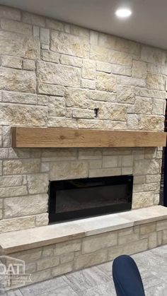 a stone fireplace in a living room next to a book shelf