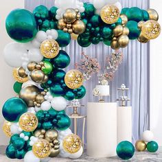 the balloon arch is decorated with gold, white and teal balloons for a party