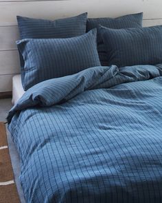 a bed with blue sheets and pillows on it