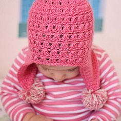 a small child wearing a pink crocheted hat