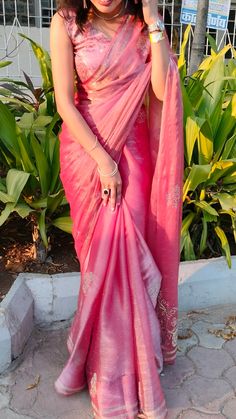 a woman in a pink sari is posing for the camera with her hand on her head