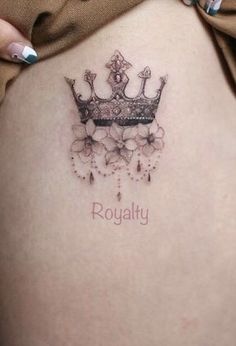 a woman's stomach with a crown tattoo on her belly and the word royalty written below it