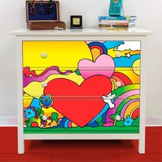 a colorful chest of drawers with a heart painted on it